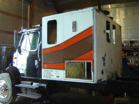 1992 Ford Bronco - Side view of a semi-truck cab, possibly in a workshop, with visible text on a tag near the door.