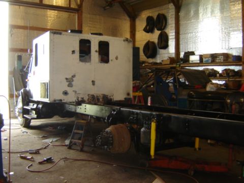 1992 Ford Bronco - A workshop scene shows a truck chassis with a white cab, possibly under restoration or repair.