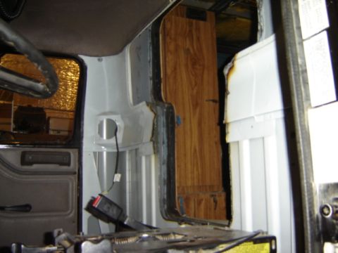1992 Ford Bronco - Interior of a vehicle showing disassembled door panel, seatbelt, and wood-paneled section.