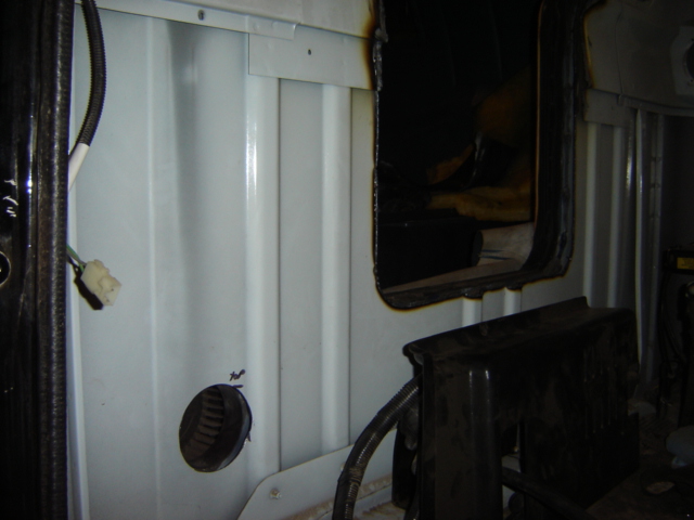 Interior paneling with wiring and a dark opening. Supermotors.net logo visible