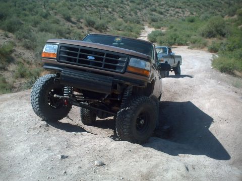 1991 Ford Bronco - This lifted 1992 Ford Bronco navigates a dusty trail, with another truck following behind.