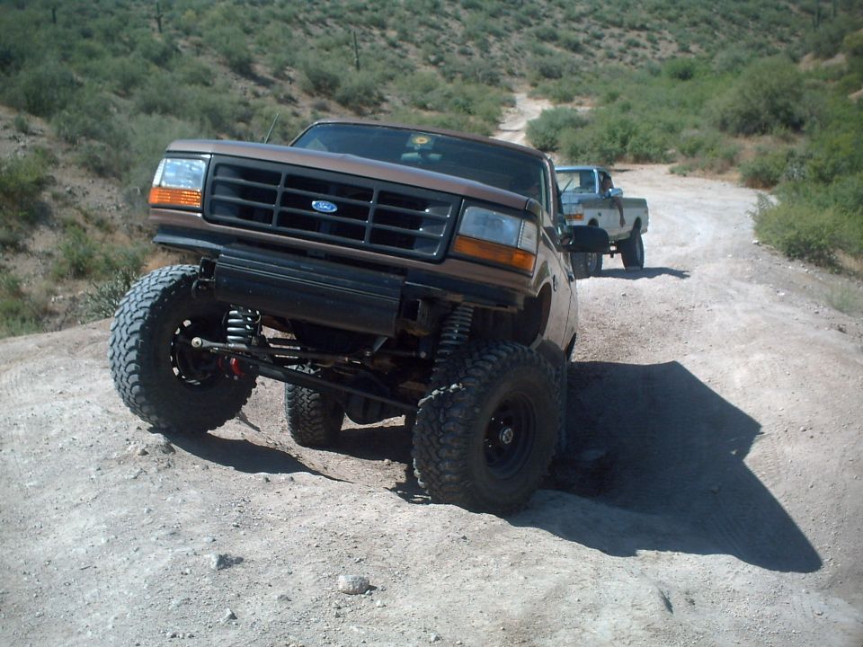 Brown lifted 1992 Ford Bronco on a dirt road