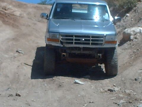 1991 Ford Bronco - Silver 1992 Ford Bronco navigating an off-road dirt path.