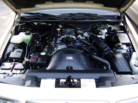 1996 Mercury Grand Marquis - The engine bay features a V8 engine with a prominent supercharger and air intake system.