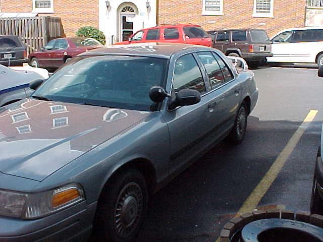 Gray Ford Crown Victoria sedan parked in a lot, front-left three-quarter view