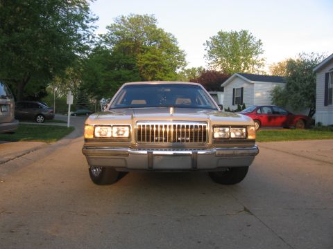 1988 Mercury Grand Marquis - Front view of a 1988 Mercury Grand Marquis parked in a driveway with other vehicles present.
