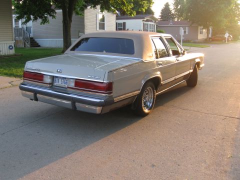 1988 Mercury Grand Marquis - Rear view of a tan 1988 Mercury Grand Marquis parked on a street.