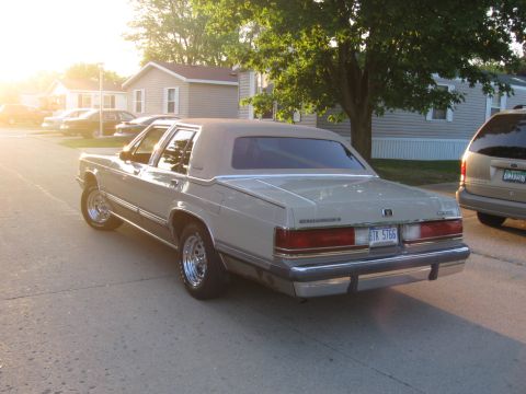 1988 Mercury Grand Marquis - Rear view of a 1988 Mercury Grand Marquis sedan parked on a residential street during sunset.