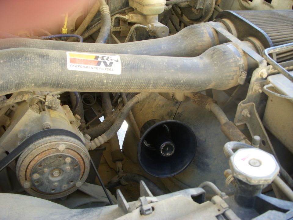 Engine bay showing air intake tubes with K&N filter sticker, AC compressor, and radiator cap