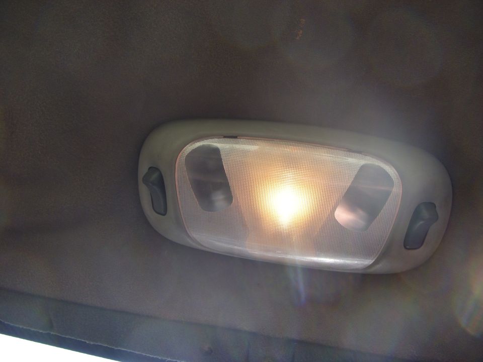 Illuminated oval dome light with map-light switches on a gray headliner