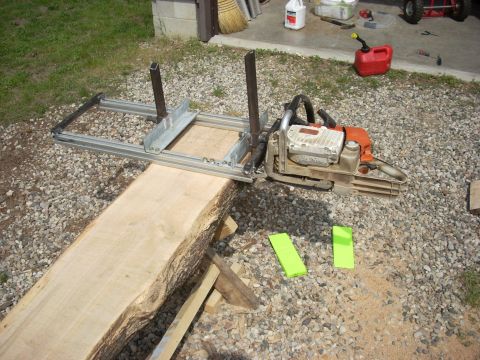 2000 Chevrolet Tahoe - A chainsaw mill attachment is set up on a log, ready for milling operations.