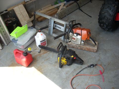 2000 Chevrolet Tahoe - Chainsaws, fuel, and oil are gathered on the floor, ready for use.