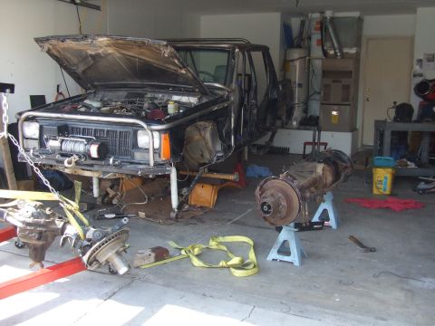 1978 Jeep Cherokee - A 1978 Jeep Cherokee is shown in a garage with its front end disassembled and axles removed for repair or modification.