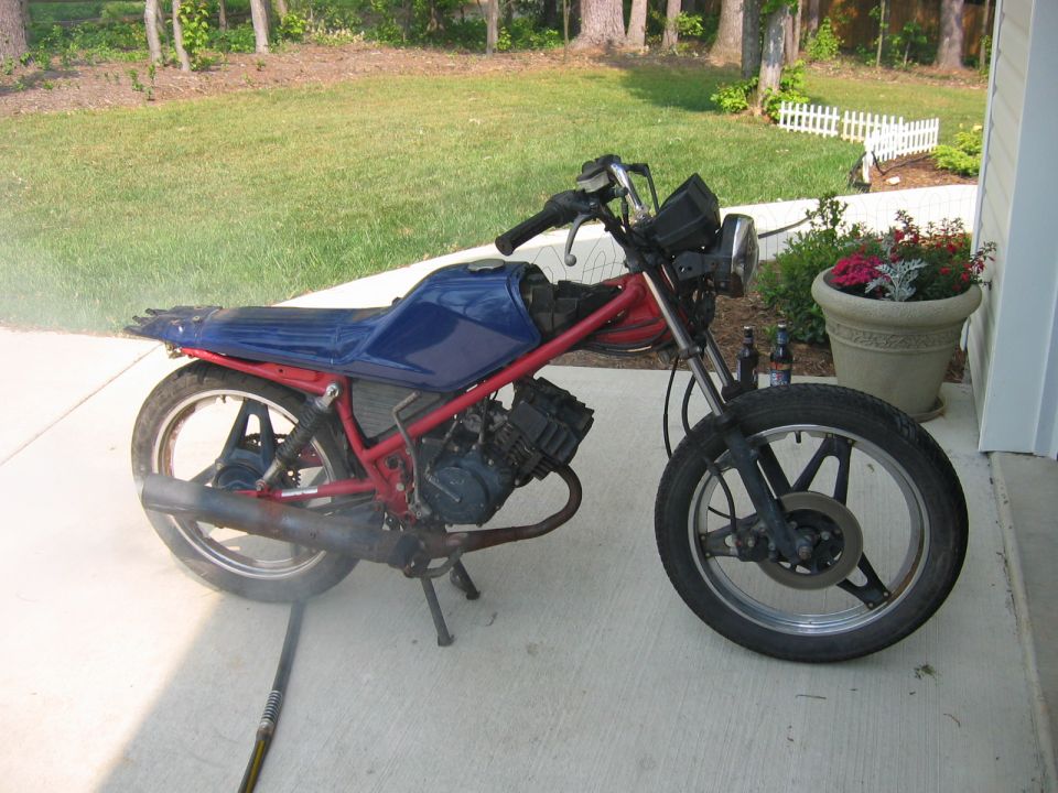 Side view of a blue and red motorcycle with a black exhaust pipe