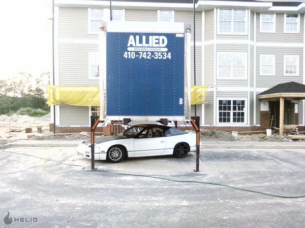 White 1991 Nissan 240SX parked under a large truck