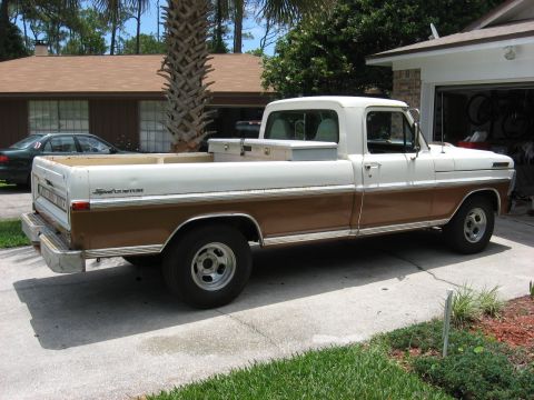 1972 Ford F-100 - A two-tone Ford F-100 pickup truck is parked in a driveway next to a garage.