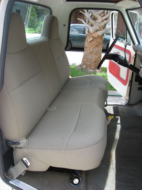 1972 Ford F-100 - Interior view of a bench seat with tan striped upholstery and red door panel accents.