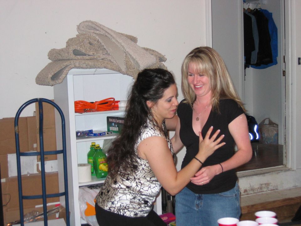 Two women in a room, one with her hand on the other's chest