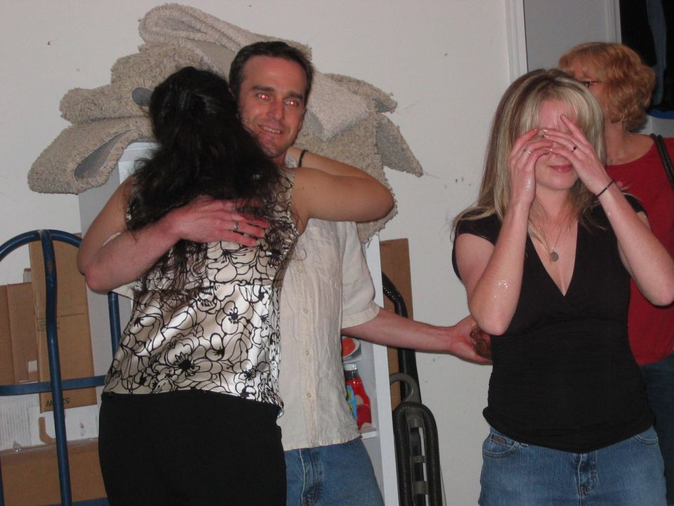 People hugging and laughing at an indoor gathering