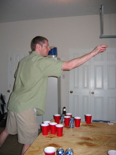 1985 Ford LTD Crown Victoria - Photo of a man playing beer pong in a garage, not a technical document.