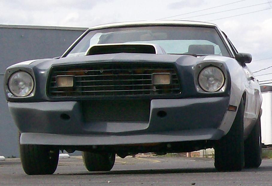 Gray primered Mustang II front end with hood scoop, quad headlights and front air dam
