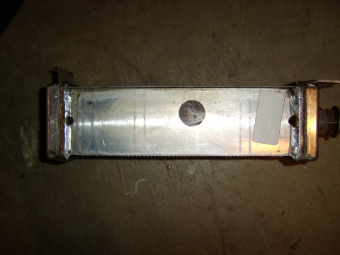 1996 Mercury Grand Marquis - A polished aluminum fabricated component, likely a heat exchanger or intercooler end tank, with welded seams at both ends, mounting bracket…