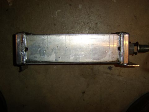 1996 Mercury Grand Marquis - A fabricated aluminum tank or heat exchanger with welded end caps sitting on a concrete floor, featuring a threaded stud fitting protruding…