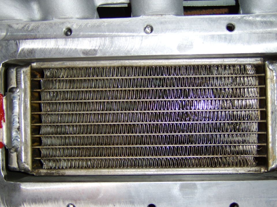 Close-up of finned aluminum intercooler/heat exchanger core in a welded housing