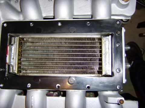 1996 Mercury Grand Marquis - Close-up top view of a supercharger intercooler core installed in a cast-aluminum intake manifold, showing the finned heat-exchanger elemen…