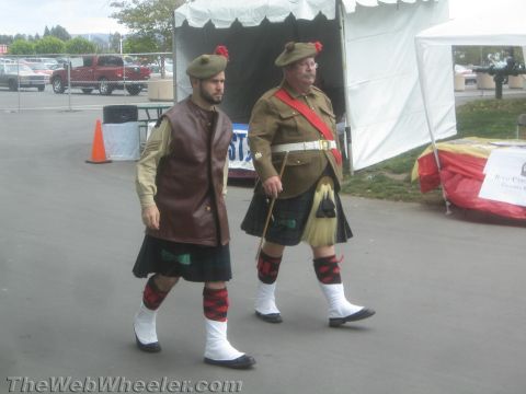 1968 Ford Mustang - Photograph of two men in kilts and Highland attire walking at an outdoor event.