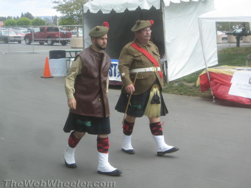 Two men in Scottish Highland dress walking at an event