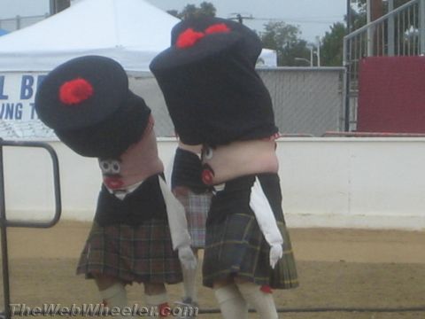 1968 Ford Mustang - Photograph of two costumed mascot figures wearing kilts performing at an outdoor event.