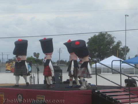 1968 Ford Mustang - Photo of costumed kilted mascot performers on an outdoor stage, not a technical document.
