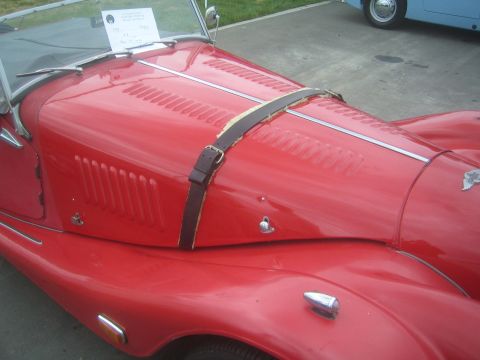 1968 Ford Mustang - Detail photo of a red Morgan roadster hood and bonnet strap, not a technical document.
