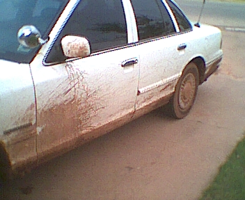 1995 Ford Crown Victoria - Side view of a mud-covered 1995 Ford Crown Victoria sedan.