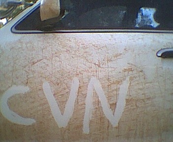 1995 Ford Crown Victoria - The side of a dirty car door with 'CVN' written on it.