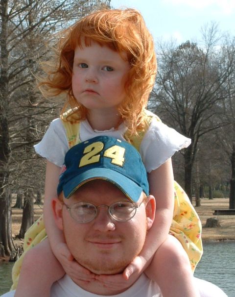 1995 Ford Crown Victoria - A man and a young girl with red hair pose for a photo outdoors near a body of water.