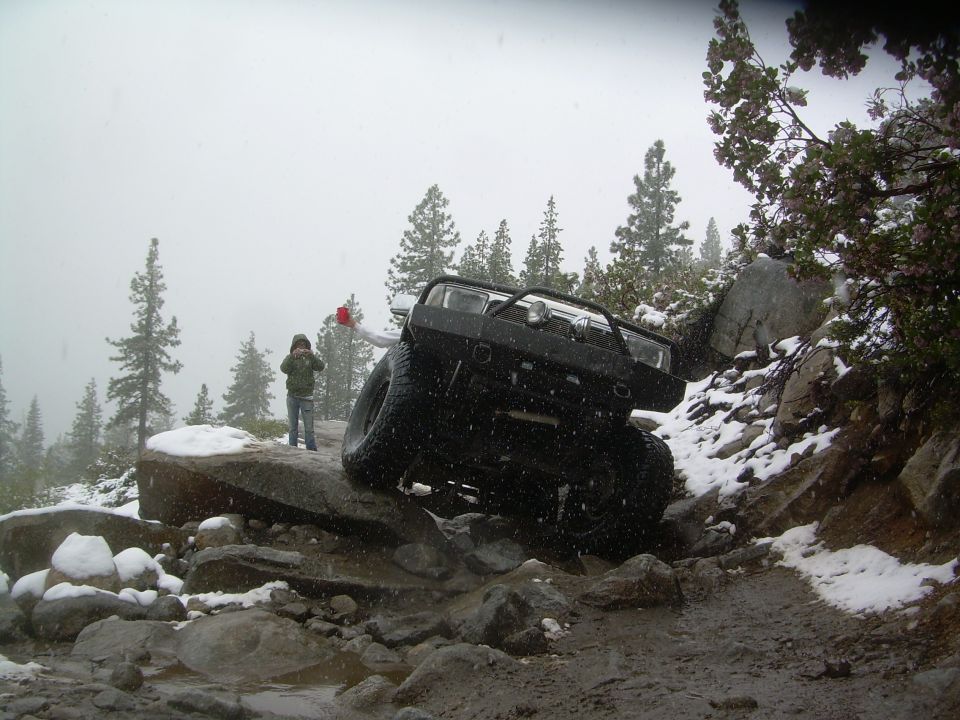 Black 4x4 SUV on a rocky, snowy trail.