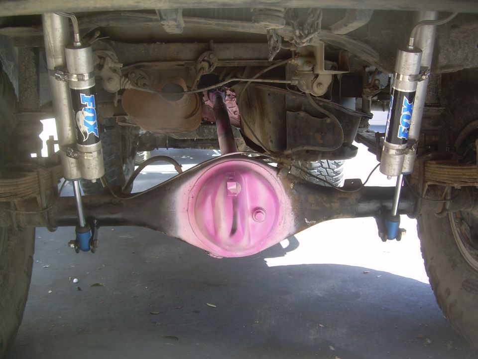 Underside of a vehicle showing a pink differential and Fox shock absorbers.