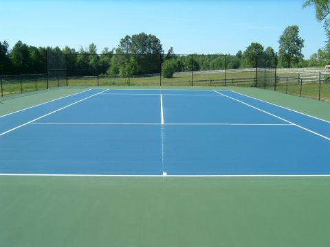 1979 Ford Ranchero - A blue and green tennis court is shown under a clear blue sky with trees and a fence in the background.
