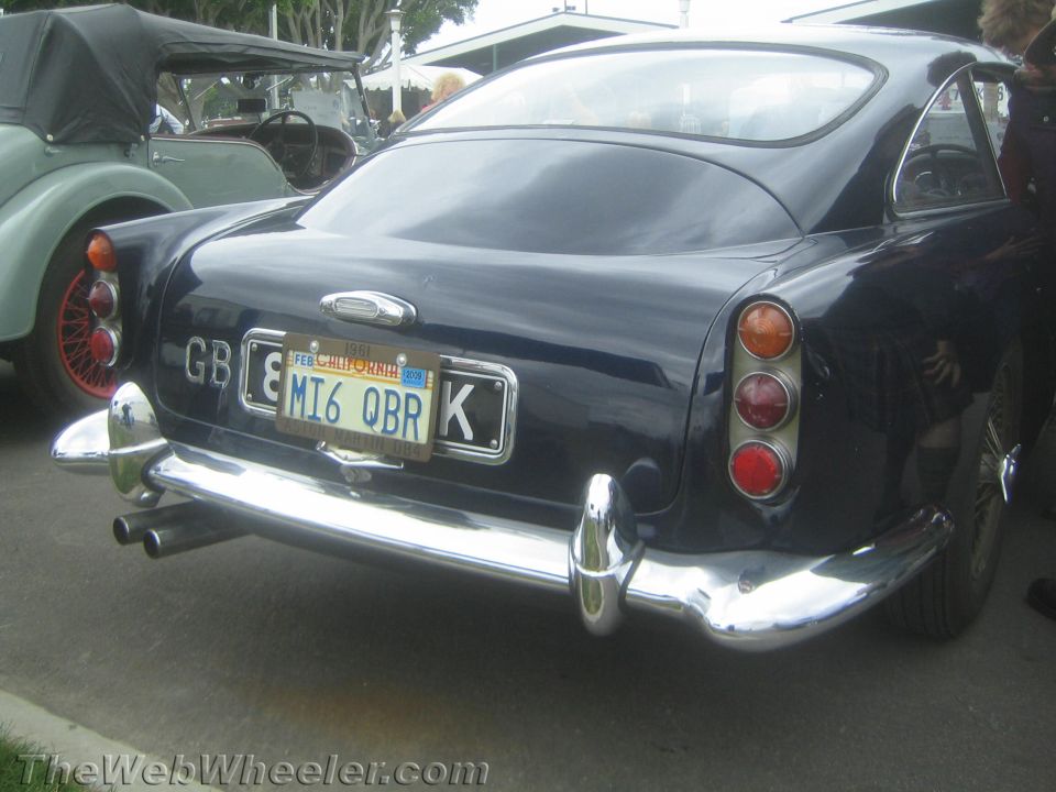 Rear view of a dark blue Aston Martin with GB plate and California plate MI6 QBR