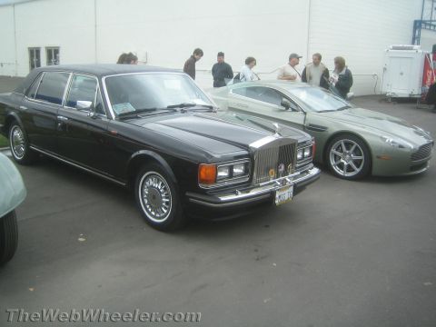 1968 Ford Mustang - Photo of a black Rolls-Royce sedan and green Aston Martin, not a technical document.