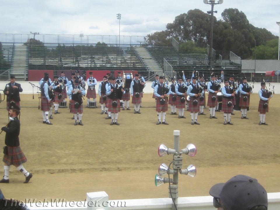 Photo of a bagpipe band performing on a field