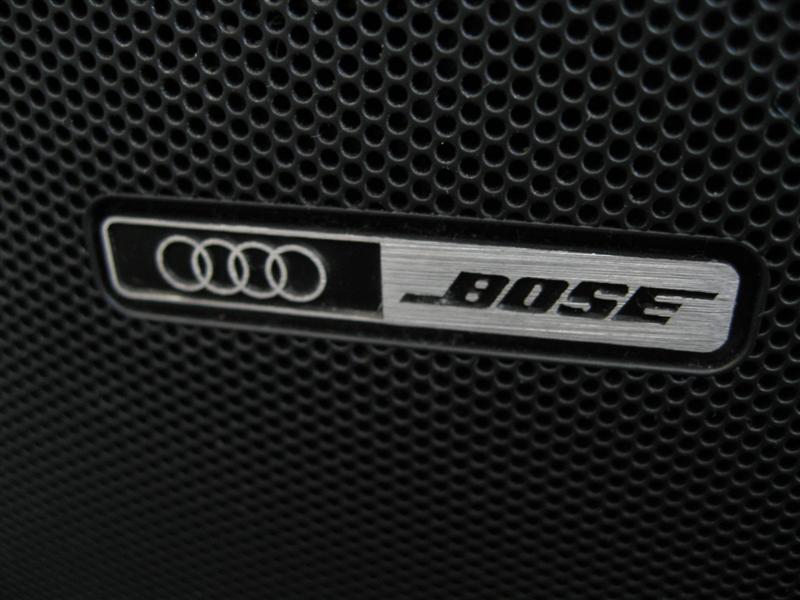 Audi and BOSE badge on a black perforated speaker grille