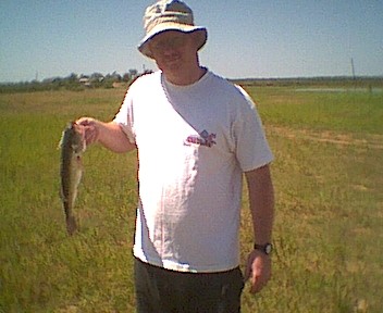 1995 Ford Crown Victoria - Man holding a fish in a field.