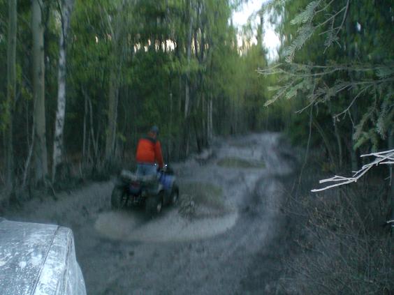 ATV riding through a muddy forest trail