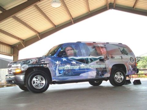 1995 Ford Crown Victoria - Chevrolet Suburban adorned with patriotic graphics and text related to Operation Iraqi Freedom.