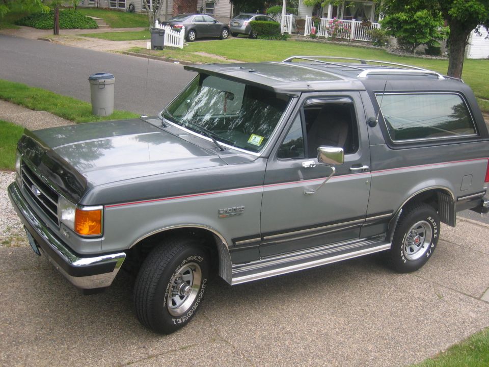 1990 Ford Bronco parked on a driveway, showing the front passenger side.