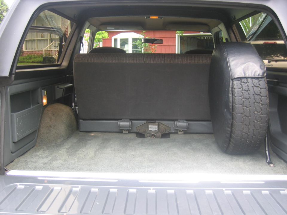 Interior cargo area of a Ford Bronco with rear seat folded and spare tire