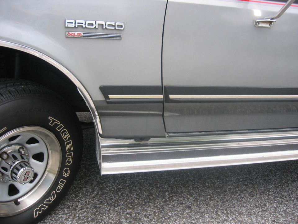 Silver 1990 Ford Bronco XLT side view showing fender, door, and running board.
